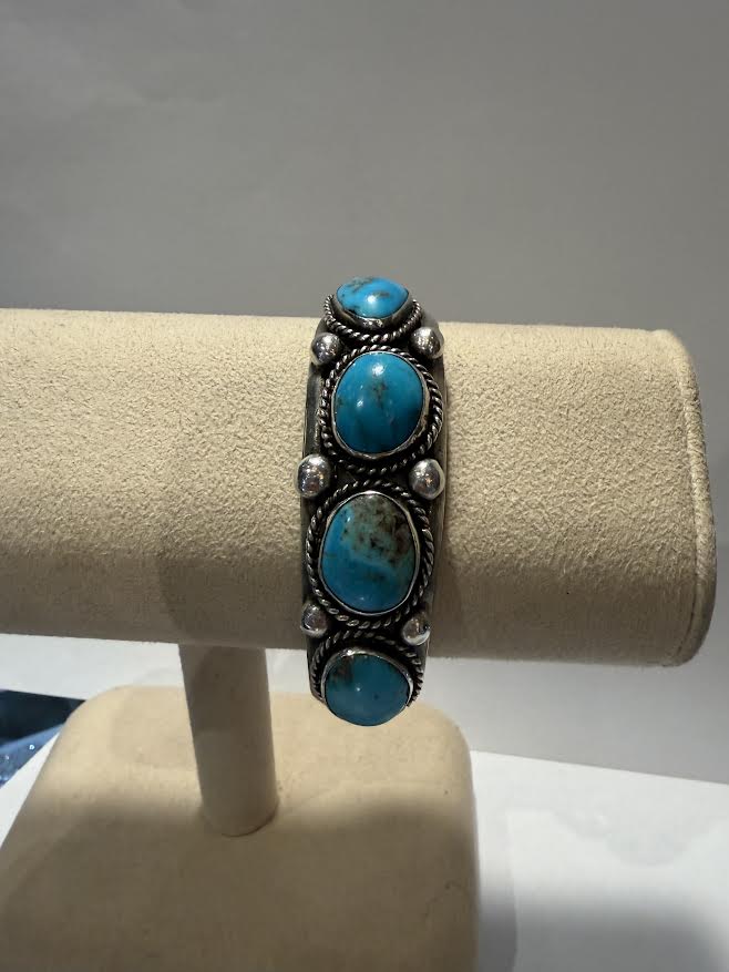 A silver cuff bracelet with 4 oval turquoise stone