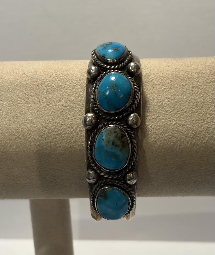 A sterling silver cuff bracelet with four oval turquoise stones