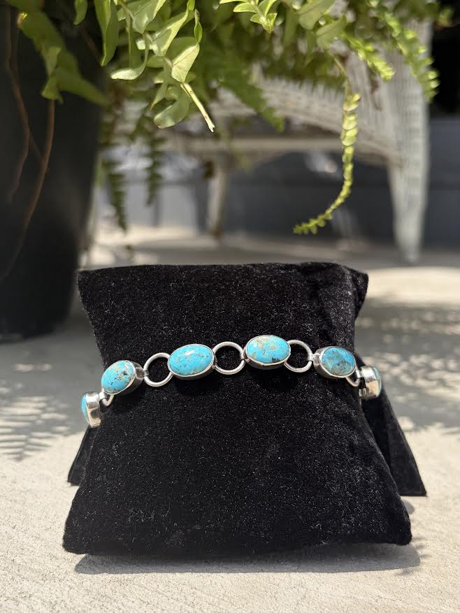 A silver bracelet with oval turquoise stone
