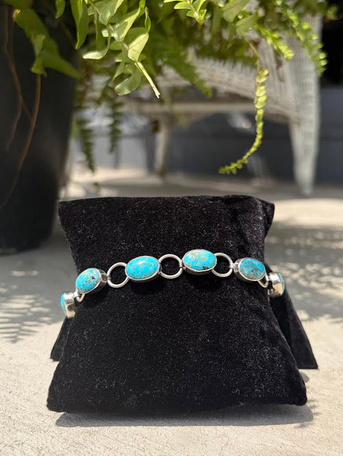 A silver bracelet with oval turquoise stone